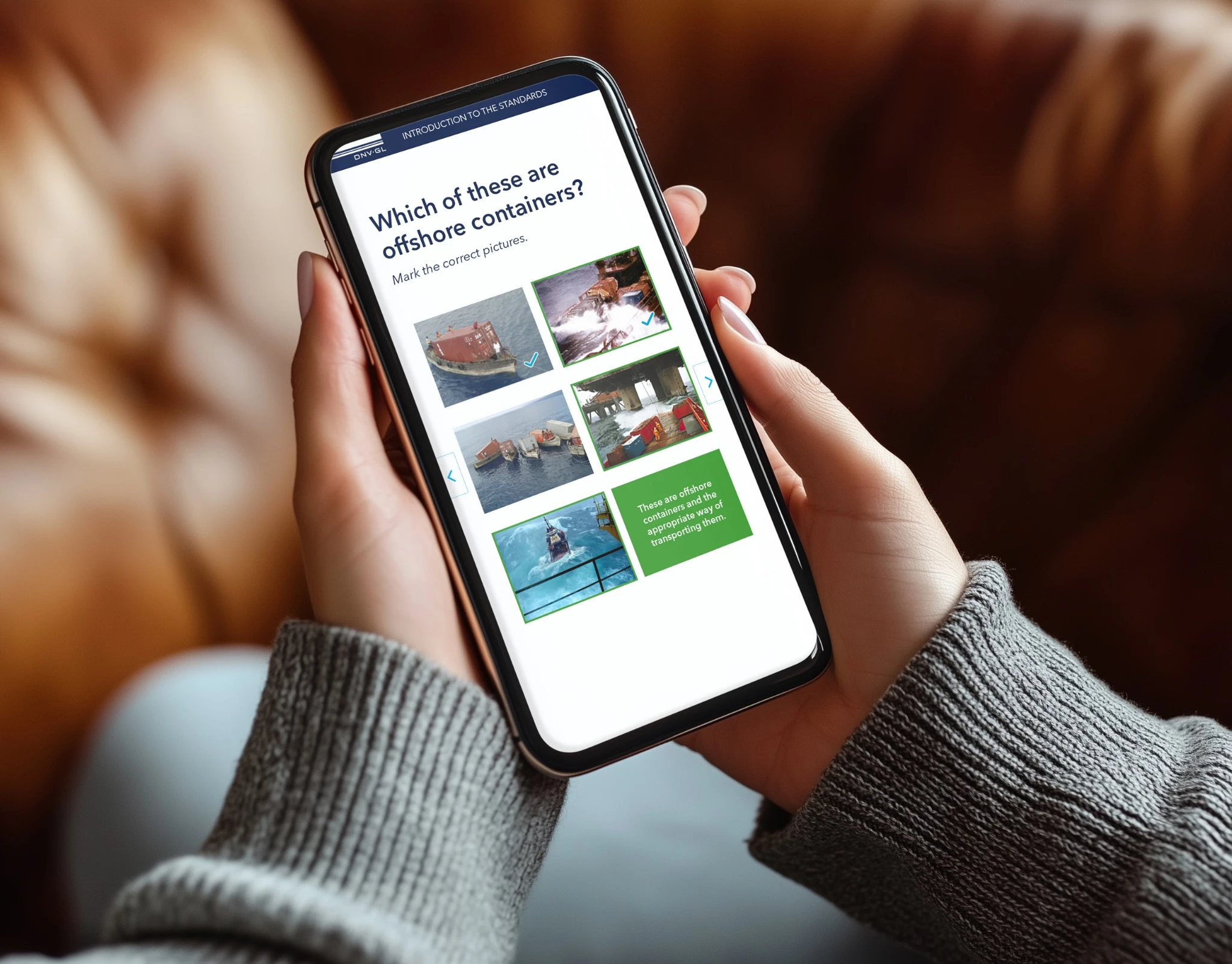 Person holding a smartphone displaying a quiz about identifying offshore containers.