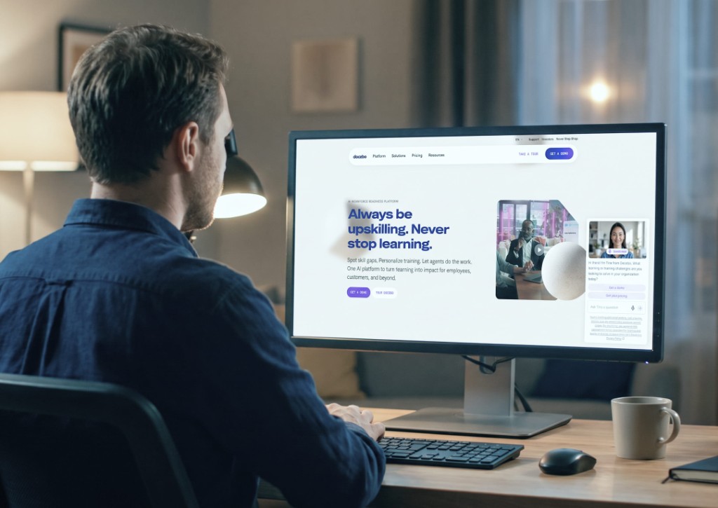 Person at a desk viewing the Docebo learning platform on a computer monitor.